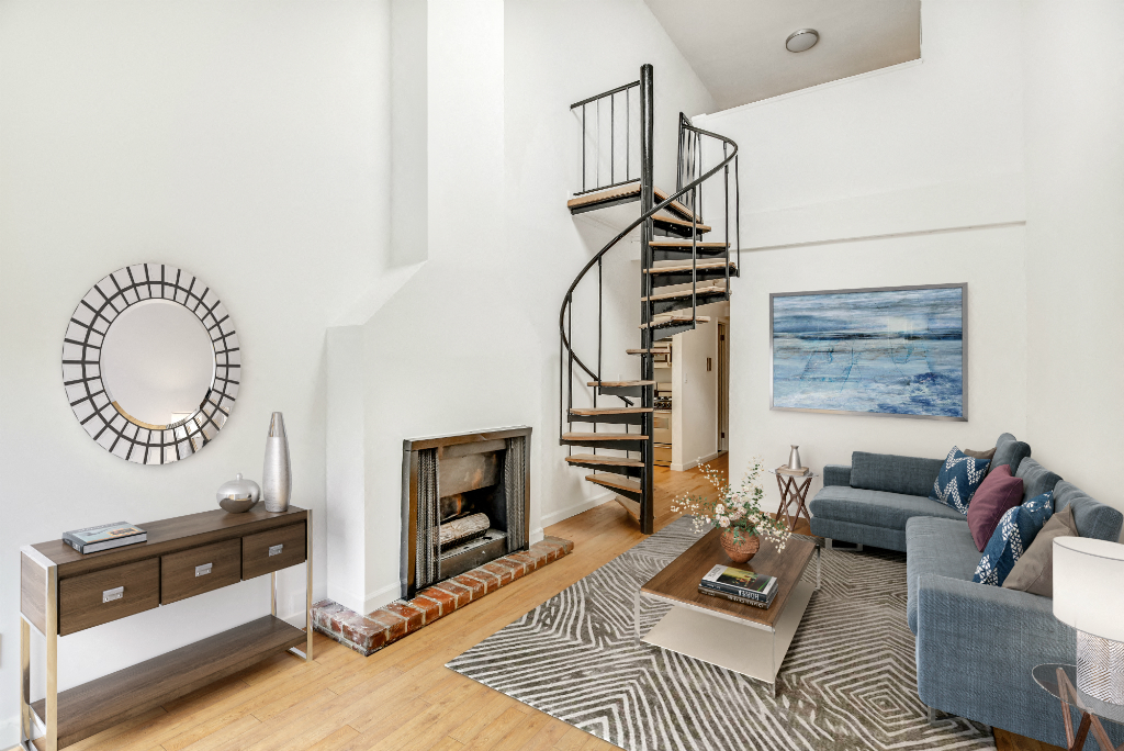 a living room with a spiral staircase and a fireplace